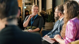 Vier Personen sitzen auf einer Bühne und diskutieren Themen der KI-Ideenwerkstatt.