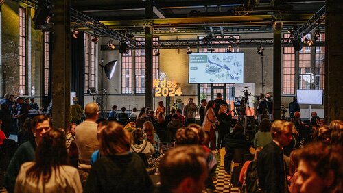 Veranstaltungsraum mit vielen Teilnehmenden in der Pause