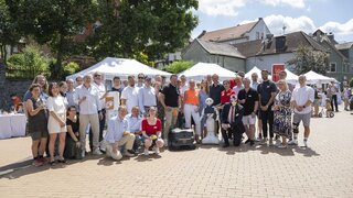 Gruppenfoto mit rund 40 Personen auf einem Marktplatz