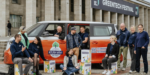 Gruppenfoto von 11 Personen neben und in einem E-Bus