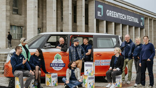 Gruppenfoto von 11 Personen neben und in einem E-Bus