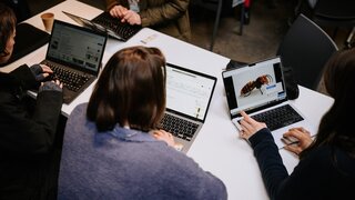 Teilnehmende sitzen vor Laptops