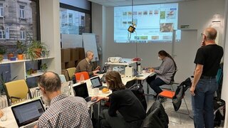 Teilnehmende des Basisworkshops in Karlsruhe sitzen am Tisch vor ihren Laptops.