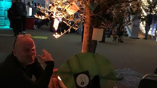 KI IW-Programmkoordinator Thorsten Kluß sitzt vor einem angestrahlten Olivenbaum