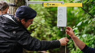 Zwei Hände halten Maßstab unter Sensor